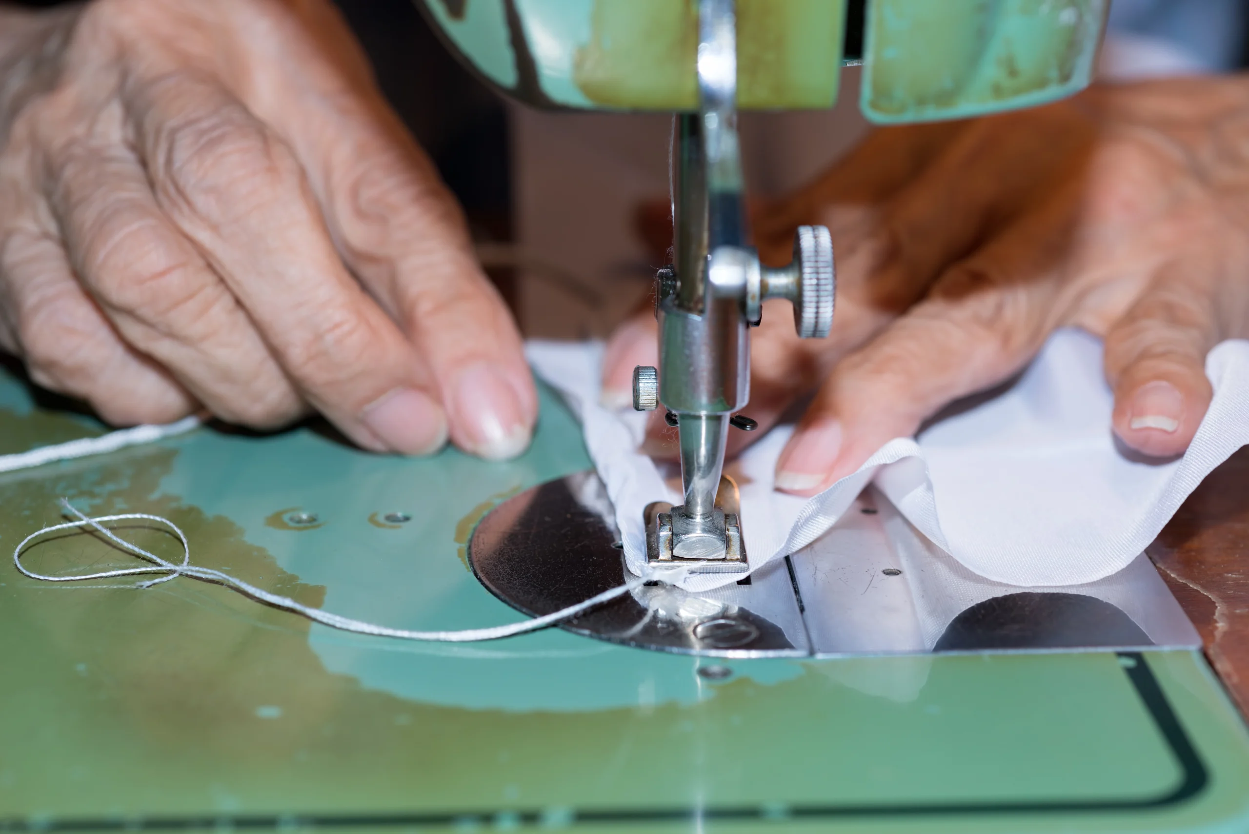 VistaCreate-126458222-stock-photo-senior-woman-with-a-sewing-machine